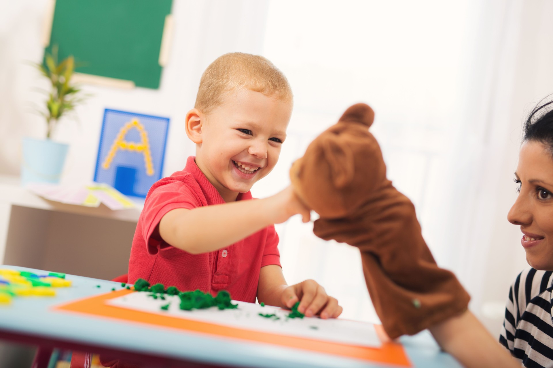 Little boy during lesson with his speech therapist.